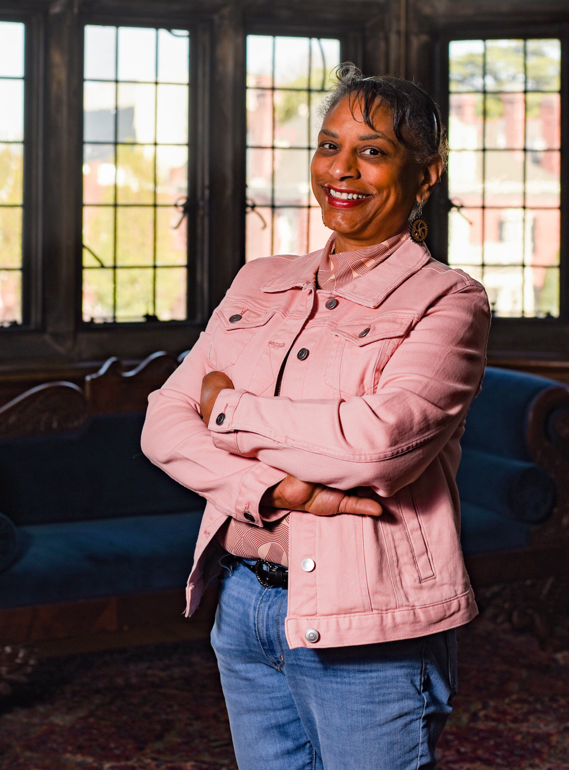 Image of Founder, Anita Crowder, wearing a pink denim jacket and jeans with her arms crossed and a welcoming smile on her face